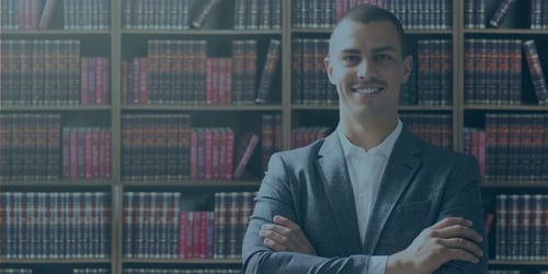Rechtsschutzversicherung mit lächelndem Anwalt vor Bücherregal