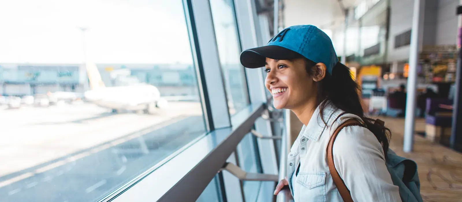 Traveller with a backpack at an airport window